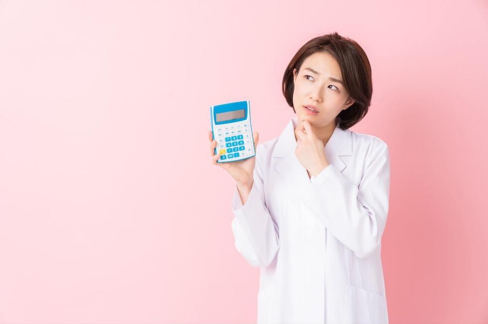 電卓を片手に首を傾げる女性
