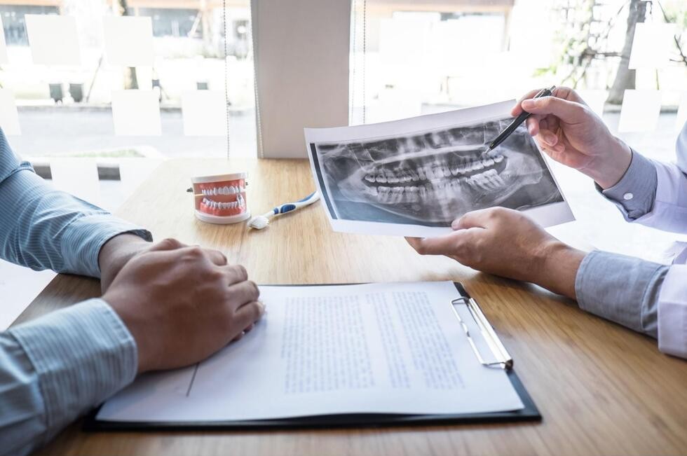 歯のレントゲンや歯の模型を使ったカウンセリングを受ける様子